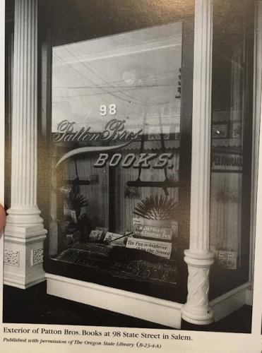 11. Image is a photograph taken from a book, showing two pillars on either side of the window of Patton Bros. Books in Salem.